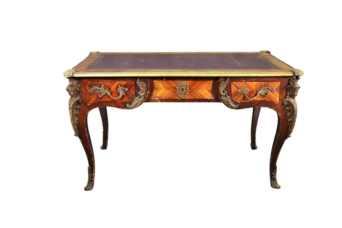 19TH C MARQUETRY BRONZE FIGURAL DESK: Marquetry. Leather top. Bronze figural accents and hardware. 3 dovetailed drawers. 30" h x 51 3/4" w x 31 1/3" d.