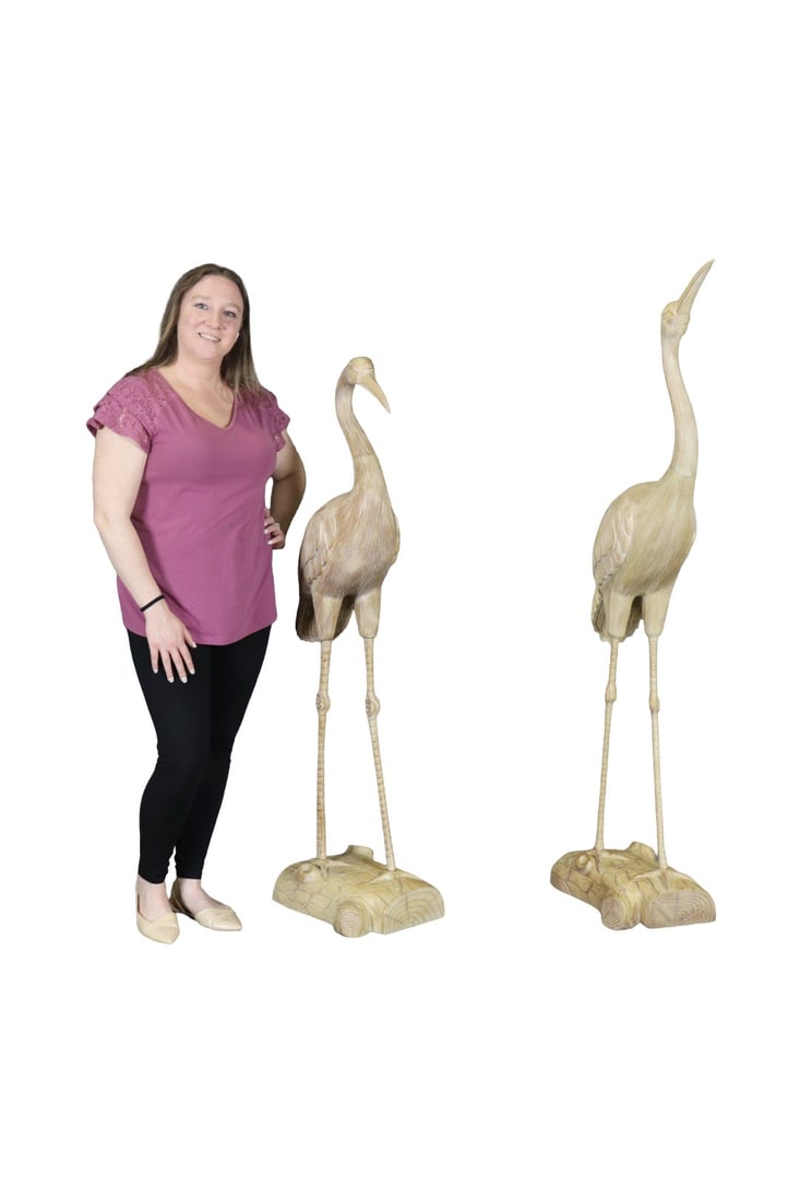 PAIR WOOD CARVED CRANE SCULPTURES: Wood. Carved. One measures 63 1/4" h x 11" w x 21" d. One measures 55" h x 11 1/2" w x 15" d.