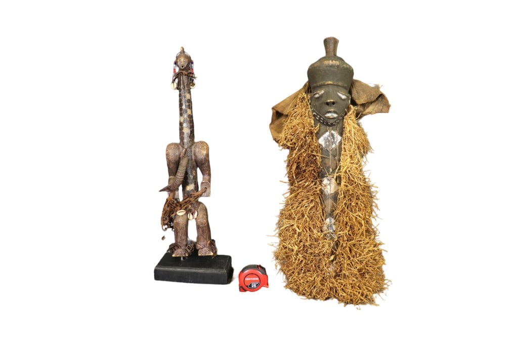 2 CARVED AFRICAN SCULPTURES: Carved. One measures 27 3/8" h x 8 5/8" w x 6" d. One measures 34" h x 16" w x 5 1/2" d.