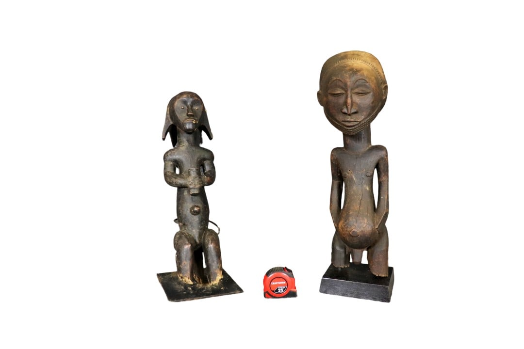 2 CARVED AFRICAN SCULPTURES: Carved wood. One on wood base. One on metal base. One measures 26" h x 9" w x 7 1/4" d. One measures 22 1/4" h x 7 7/8" w x 8" d.
