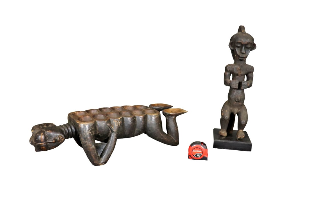 2 CARVED AFRICAN SCULPTURES: Carved wood. One on wood base. One measures 24" h x 7 1/4" w x 6 7/8" d. One measures 27 1/2" h x 9 1/2" w x 8" d.