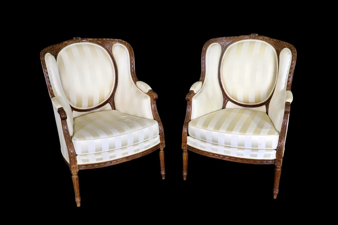 PAIR LOUIS XVI STYLE CARVED WALNUT BERGERES: Upholstered. Carved walnut. 39 3/4" h x 29" w x 29 1/2" d. Seat height 19".