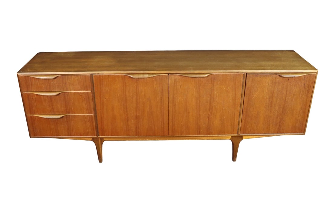 MID CENTRY MODERN TEAK SIDEBOARD: Teak. 4. AH Macintosh & CO LTD label in door. 3 dovetailed drawers on left. 2 doors in middle containing one shelf. One drop down door on right. 30" h x 79 1/4" w x 18 3/4" d.