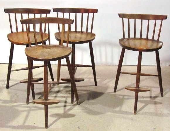4 GEORGE NAKASHIMA BAR STOOLS: American walnut. In need of restoration. Damaged stretchers with one replaced. One missing spindle with one replaced. Some small damages.