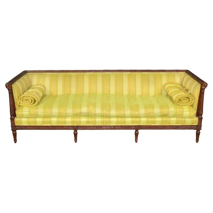FRENCH LOUIS XVI STYLE CARVED WALNUT SOFA/SETTEE: Walnut frame. Upholstered. Carved. Fluted legs. Circa 1940's. 29" h x 87" w x 29 1/2" d. Seat height 19".