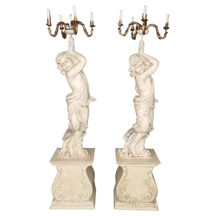 PAIR LIFE SIZE CARVED WOOD NEOCLASSICAL CHERUB TORCHIERES FLOOR LAMPS: Circa 1950's. Cherub figural. Wood. Gilt accented metal candelabras. 85" h x 19" w x 19" d.