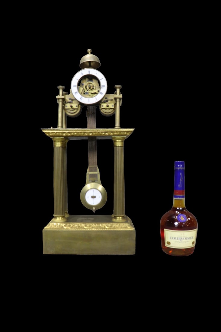 BRONZE EMPIRE MECHANICAL CLOCK WITH PENDULUM: Bronze. With pendulum. 24 1/8" h x 10 1/2" w x 5 3/4" d.