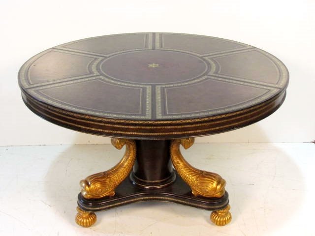 MAITLAND SMITH FRENCH EMPIRE STYLE CENTER TABLE: Leather covered with gilt dolphins. Scratches on leather. Very good condition. 29 1/2"h. x 48"diam.