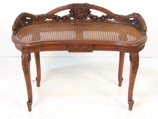 FRENCH CARVED WALNUT CANED BENCH: Very good condition. 25"h. x 35"w. x 16"d.