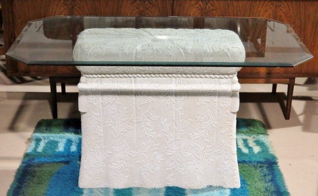 DECORATIVE MOLDED PLASTER DRAPE TABLE: Glass top. Molded plaster. Very good condition. Very tiny corner chip on glass. 29 1/2"h. x 53"w. x 29 1/2"d.