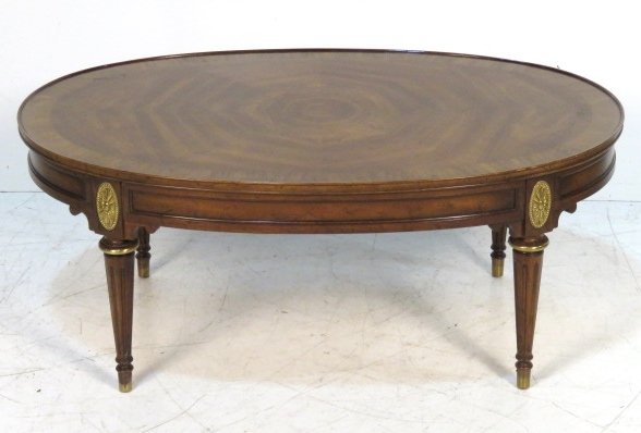 DREXEL HERITAGE OVAL BANDED COFFEE TABLE: Walnut with brass mounts. 17 1/2"h. x 42"w. x 27"d.