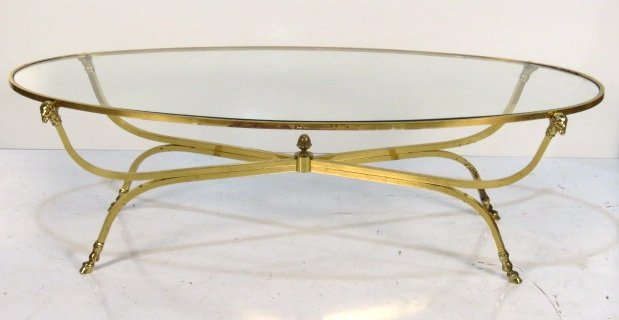 NEOCLASSICAL STYLE OVAL BRASS GLASSTOP COFFEE TABLE: Hoof feet and rams heads. 16 1/2"h. x 54 1/2"w. x 25 1/2"d.