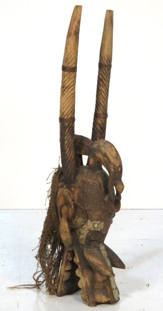 ANTIQUE AFRICAN CARVED DRAGON TRIBAL MASK: Carved wood dragon head with horns. Applied sheet metal plates. 28"h.