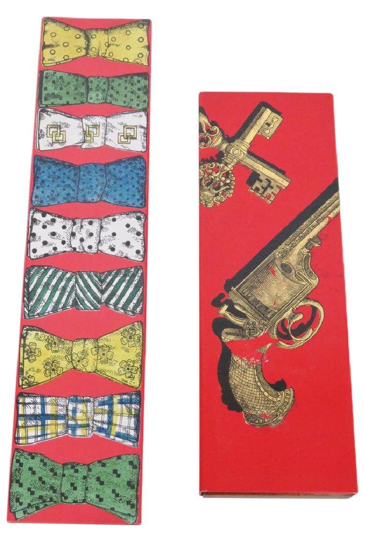 2 FORNASETTI CIGAR BOXES: One with bow ties, and the other with a gun and keys. Marked Fornasetti-Milano, Made in Italy. Bow tie box measures 15 1/2"w. x 3 1/2"d.