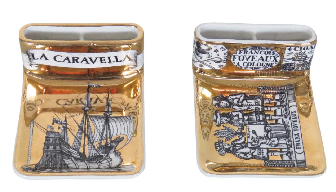 2 FORNASETTI CIGARETTE HOLDER/ASH TRAY: Ash trays with gilt backgrounds with French figural scenes. Marked Fornasetti-Milano, Made in Italy. 2"h. x 5 1/2"w. x 4"d.