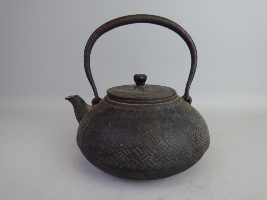 Antique Japanese Cast Iron Teapot: Tetsubin, marked to one side Size: 8" H (inclusive of handle) x 7 1/2" L (to spout) x 7 1/2" W