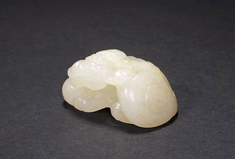 A Chinese White Jade Lion: A well carved Chinese white jade join, reclined with a brocade ball under its paws, appeared to be carved from a small jade pebble, 1.5" W