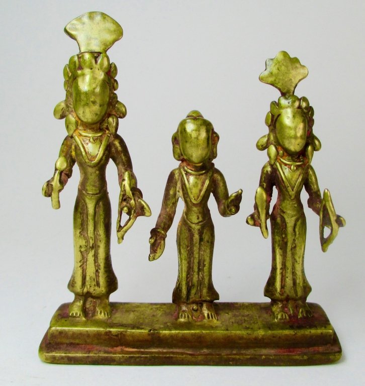 An Antique Nepalese Bronze Figural Group: An antique Nepalese bronze figural group depicting three standing Buddha deities, with each holding different instruments in hands. Possible 11-13th century, faces have been rubbed to smooth (for bles