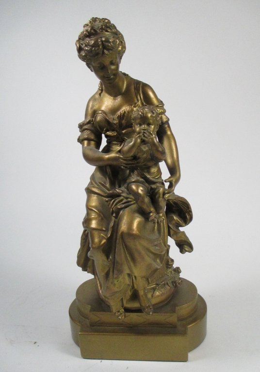 AFTER MATHURIN MOREAU (French, 1822-1912): A gilt metal figural group, likely spelter, depicting a seated mother and child, raised on the affixed stepped plinth. Size: 17" H