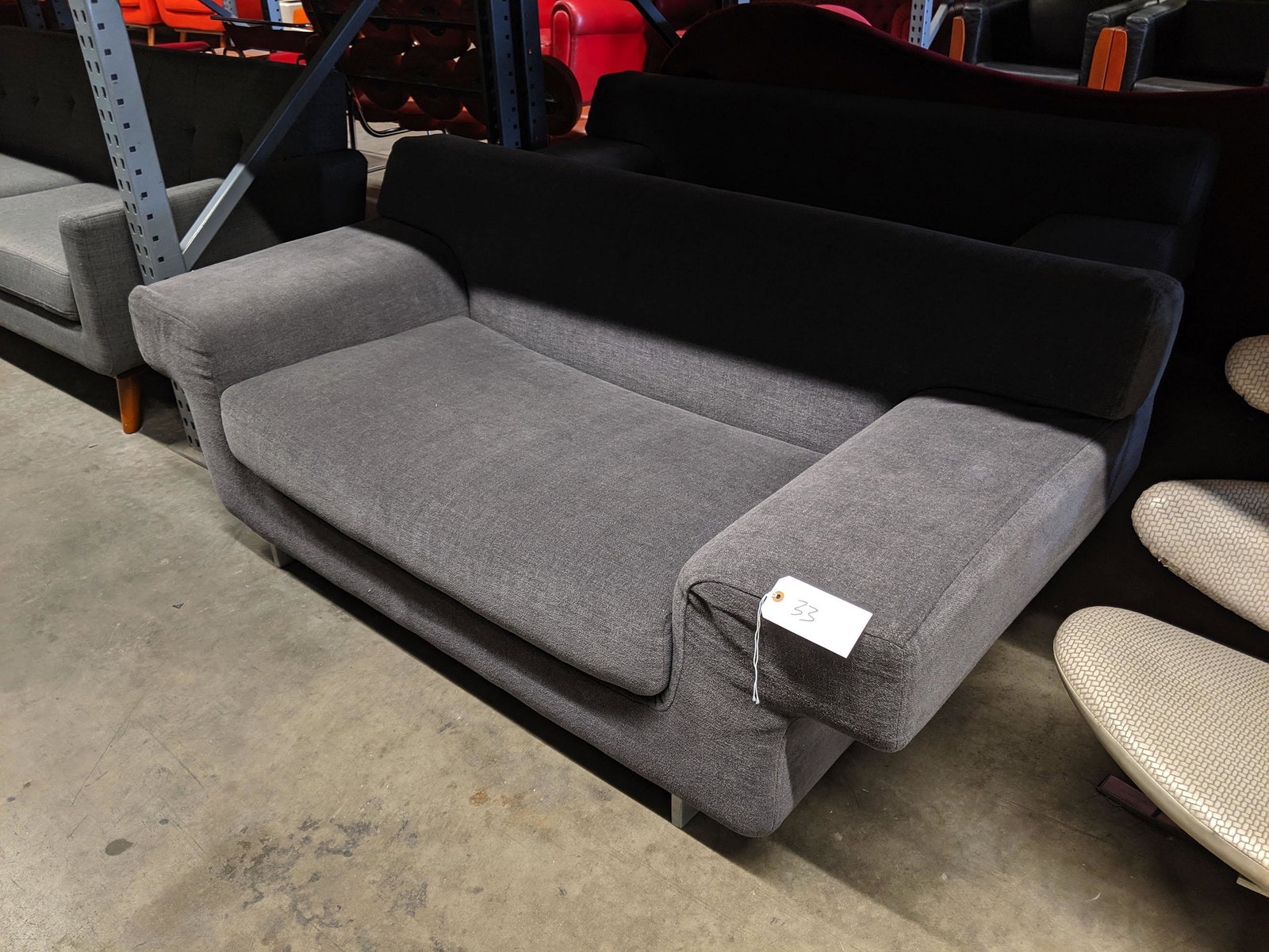 Loveseat: Loveseat with gray upholstery and cast metal legs.