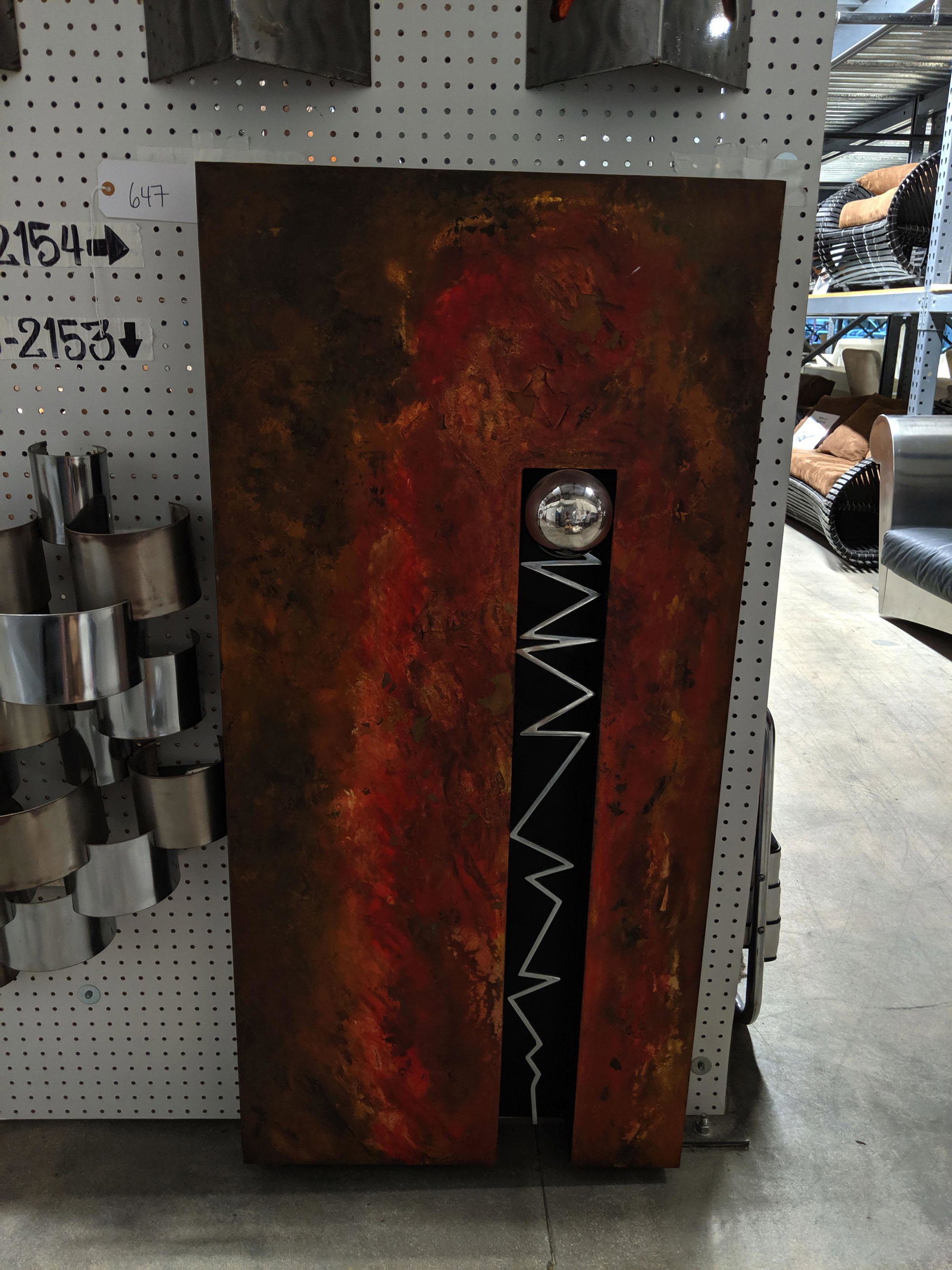 Wall Sculpture: Rectangular metal wall sculpture with spear.