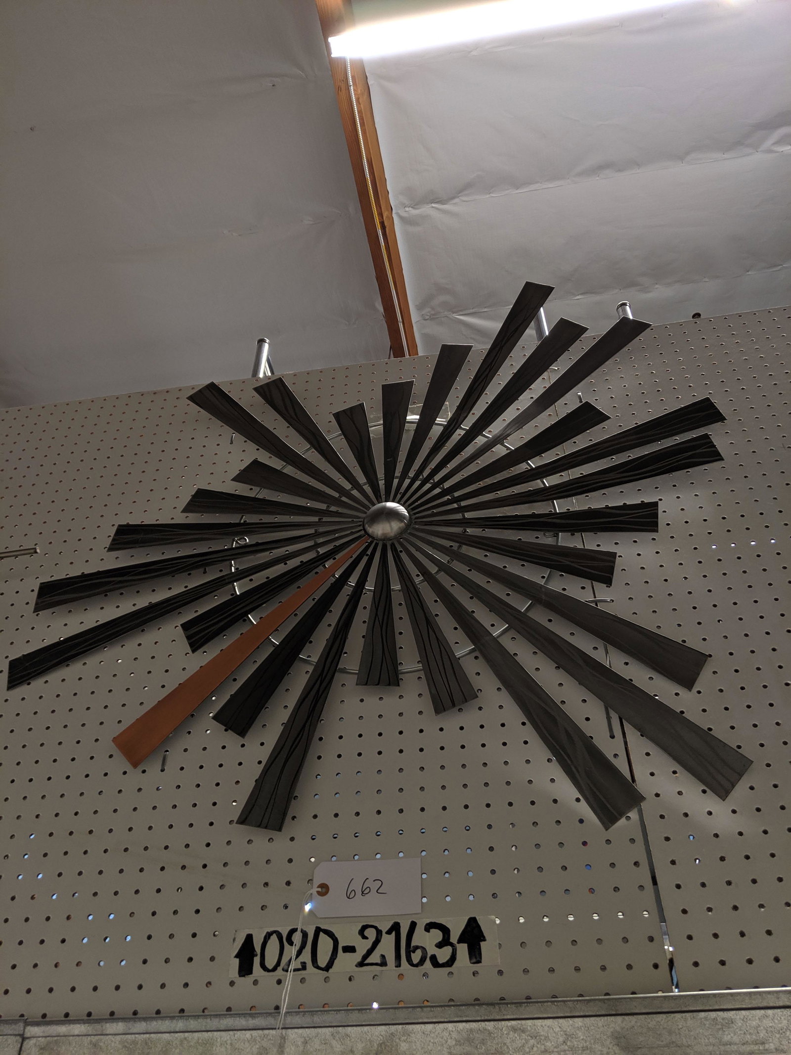 Raised Wall Sculpture: Metal wall sculpture with emanating rays.