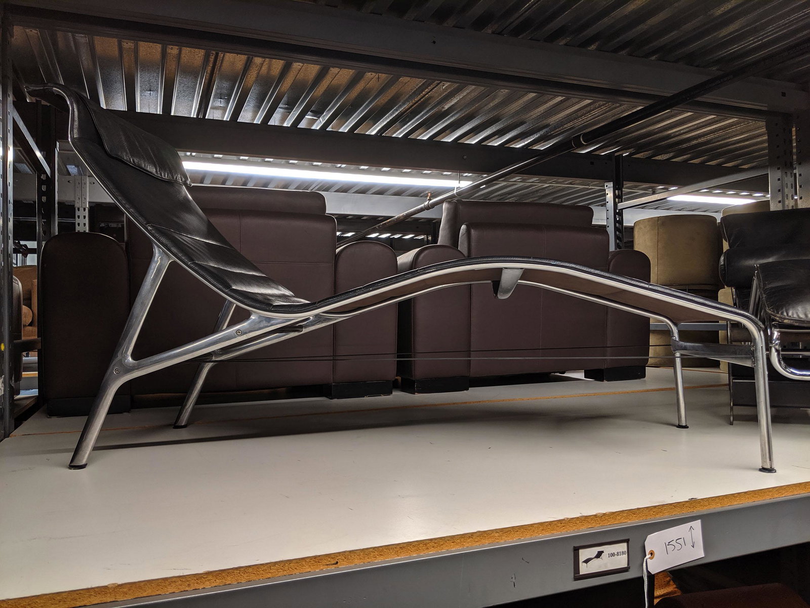 Aluminum Chaise Longues: Pair of aluminum chaise longues with leather upholstery.