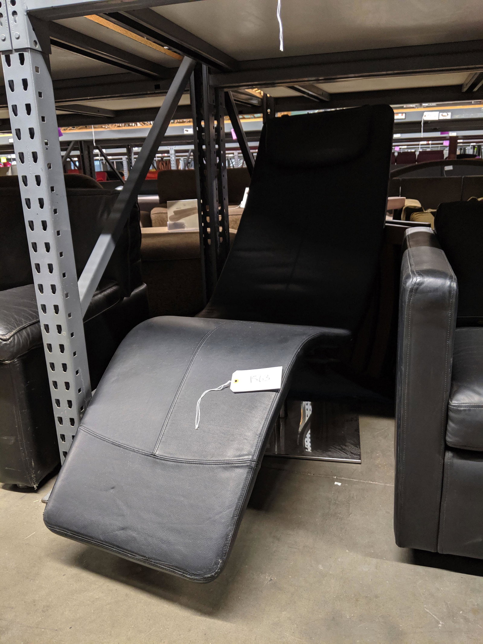Swiveling Chaise: Black leather swiveling chaise.