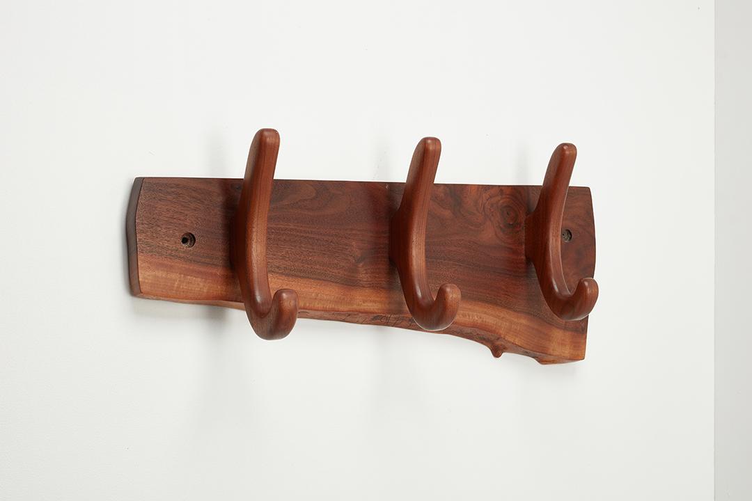 Sam Maloof Studio, Wall-Mounted Coat Rack: Sam Maloof Studio Wall-mounted coat rack, 21st Century Walnut. Produced by Sam Maloof Woodworker, Inc., USA. Verso with producer's mark. 10.5" H x 24" W x 5.25" D