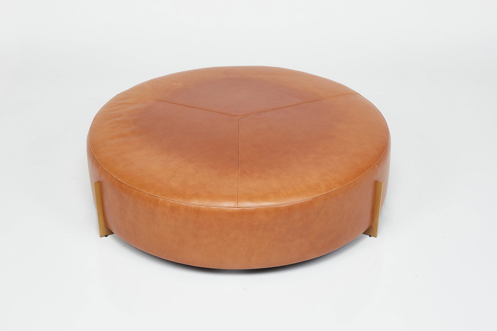 Thomas Pheasant, 'Blade' Ottoman: THOMAS PHEASANT'Blade' ottoman, 2010sLeather, brushed brass. Manufactured by Baker Furniture, USA.Underside with manufacturer's fabric label.14" H x 48" Diameter