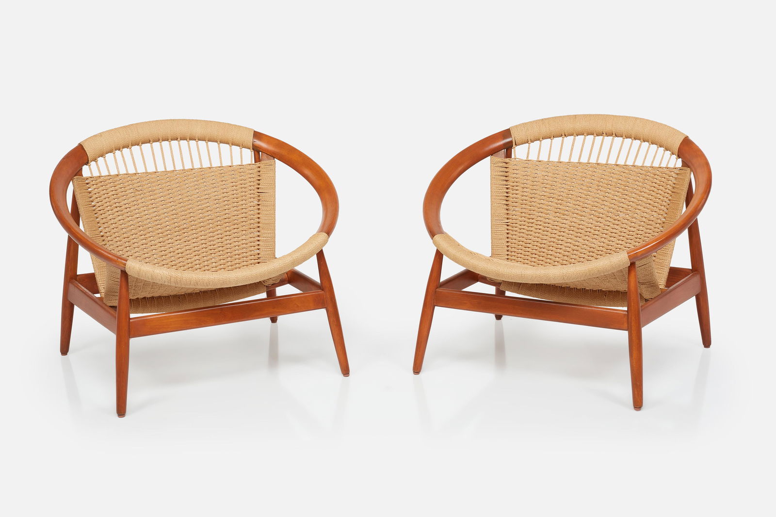 Illum Wikkelso, 'Ringstol' Chairs (2): ILLUM WIKKELSOPair of 'Ringstol' lounge chairs, ca. 1965Teak, cotton cord. Manufactured by Niels Eilersen, Denmark.Each: 26.5" H x 31.5" W x 30" DSeat height: 14"