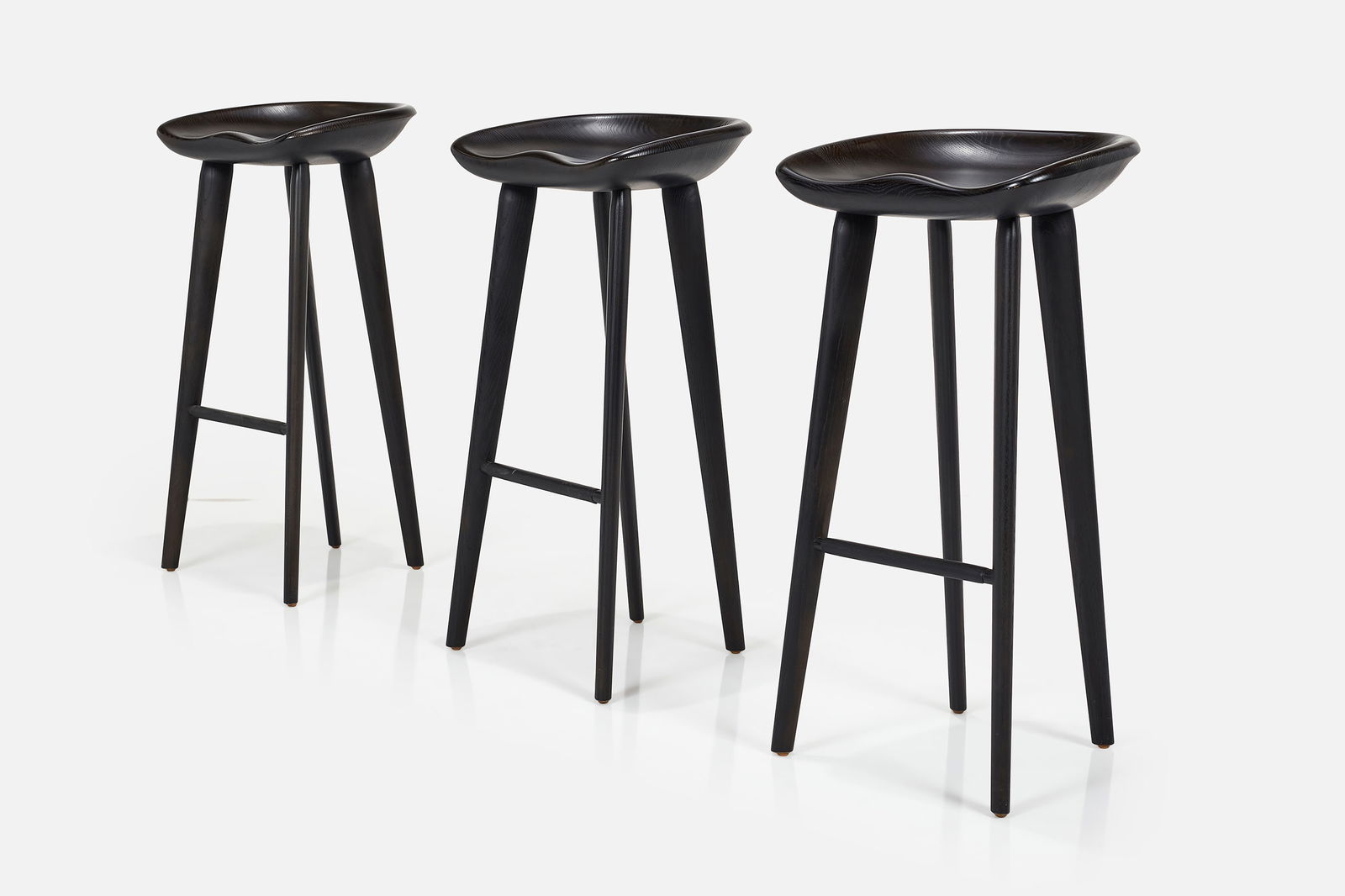 Craig Bassam, 'Tractor' Barstools (3): CRAIG BASSAMSet of three 'Tractor' stools, model no. C-23, 2000Ebonized wood, leather. Manufactured by BassamFellows, USA.Underside with manufacturer's mark. Each: 32.5"