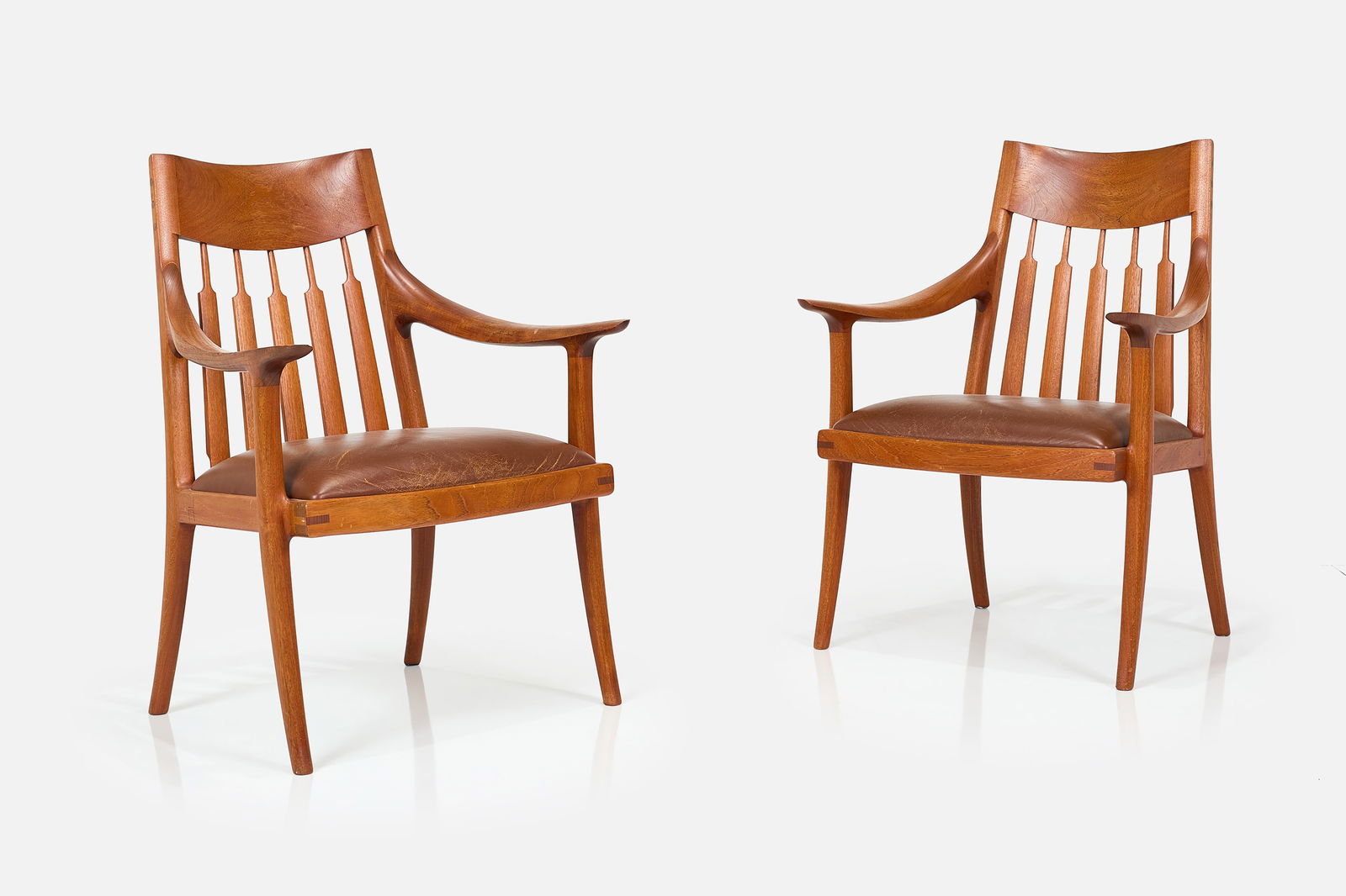 John Nyquist, Easy Chairs (2): JOHN NYQUISTPair of easy chairs, ca. 1972Walnut, leather. Studio-made, Long Beach, CA.Side of seat incised "JN". Each: 36.75" H x 27.25" W x 27" DSeat height: 18.5"