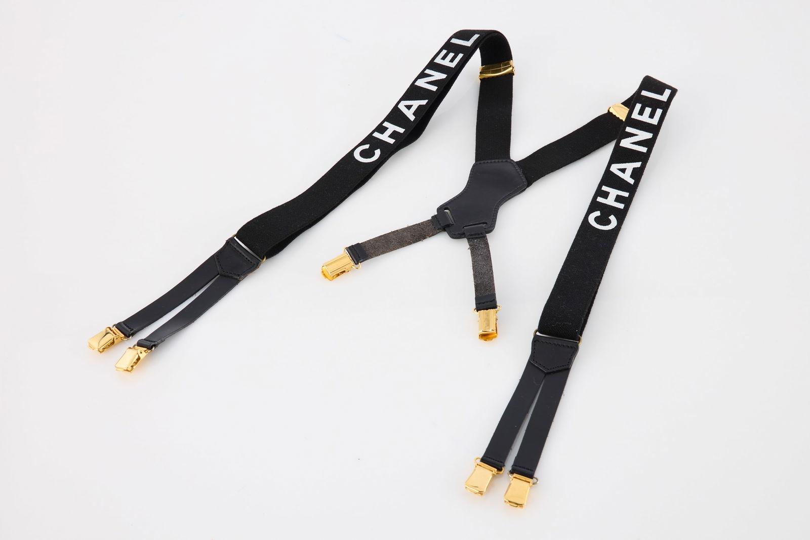 Chanel, Collectible Suspenders: S/S 1994 CHANELCollectible suspenders.Elastic with white Chanel logo, leather trim, gold hardware. Designed by Karl Lagerfeld. Length 31.5" (80 cm), Width 1.5" (4 cm)