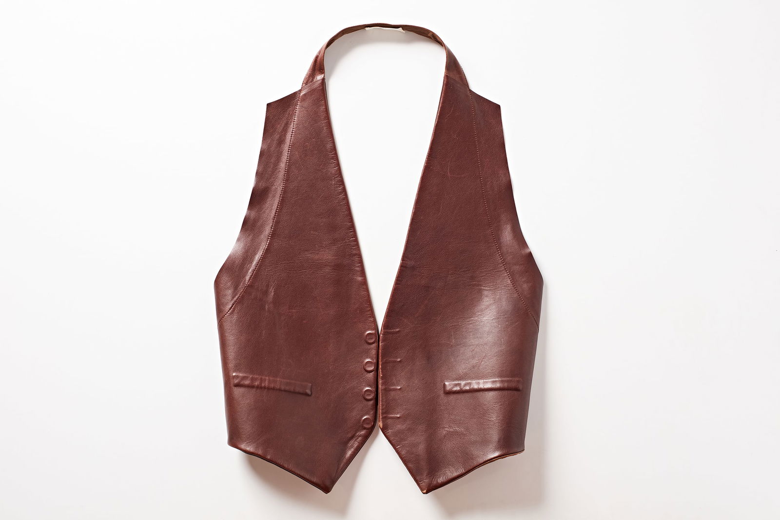 F/W 2001 Maison Martin Margiela, Oversized Backless Vest: F/W 2001 MAISON MARTIN MARGIELABackless oversized vest with compressed button and pocket detailing and adjustable buckled strap.Leather. Designed by Martin Margiela.Interior with blank fabri