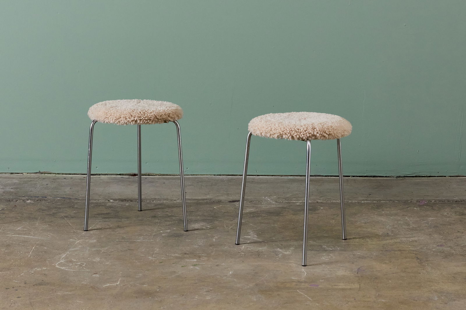 Arne Jacobsen, Stacking Stools (2): ARNE JACOBSEN Pair of stacking stools, 1960s Chrome-plated steel, faux shearling. Manufactured by Fritz Hansen, Denmark. Underside molded with manufacturer's mark. Each: 18" H x