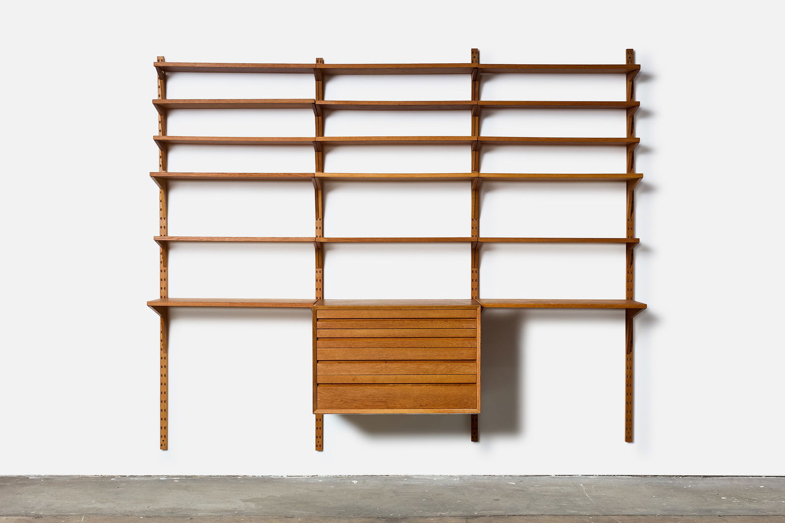 Poul Cadovious, 'Royal' Wall Unit: POUL CADOVIUS'Royal' wall mounted shelving unit, 1960sTeak, brass. Manufactured by Cado, Denmark. 78" H x 98" W x 16" D