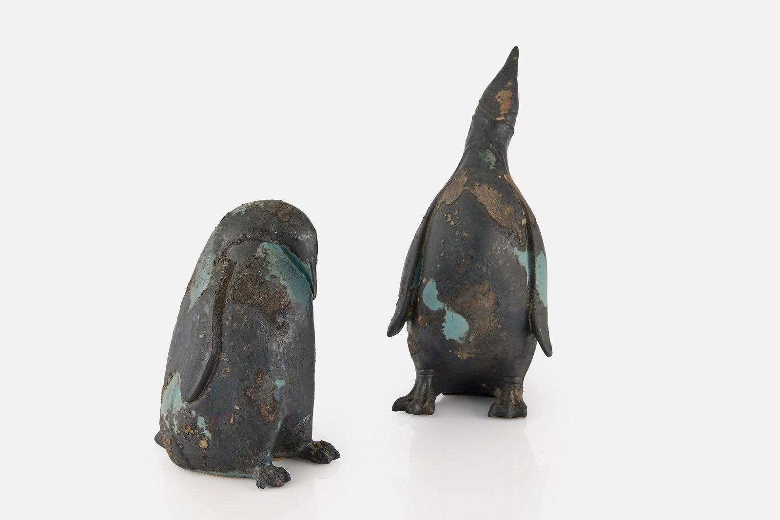 Tony Evans, Penguin Sculpture (2): TONY EVANS Two penguin figures, 1970s Raku-fired ceramic. Signed and numbered "218", and also with a sticker to the underside of one. Taller: 13" H x 6.5" W x