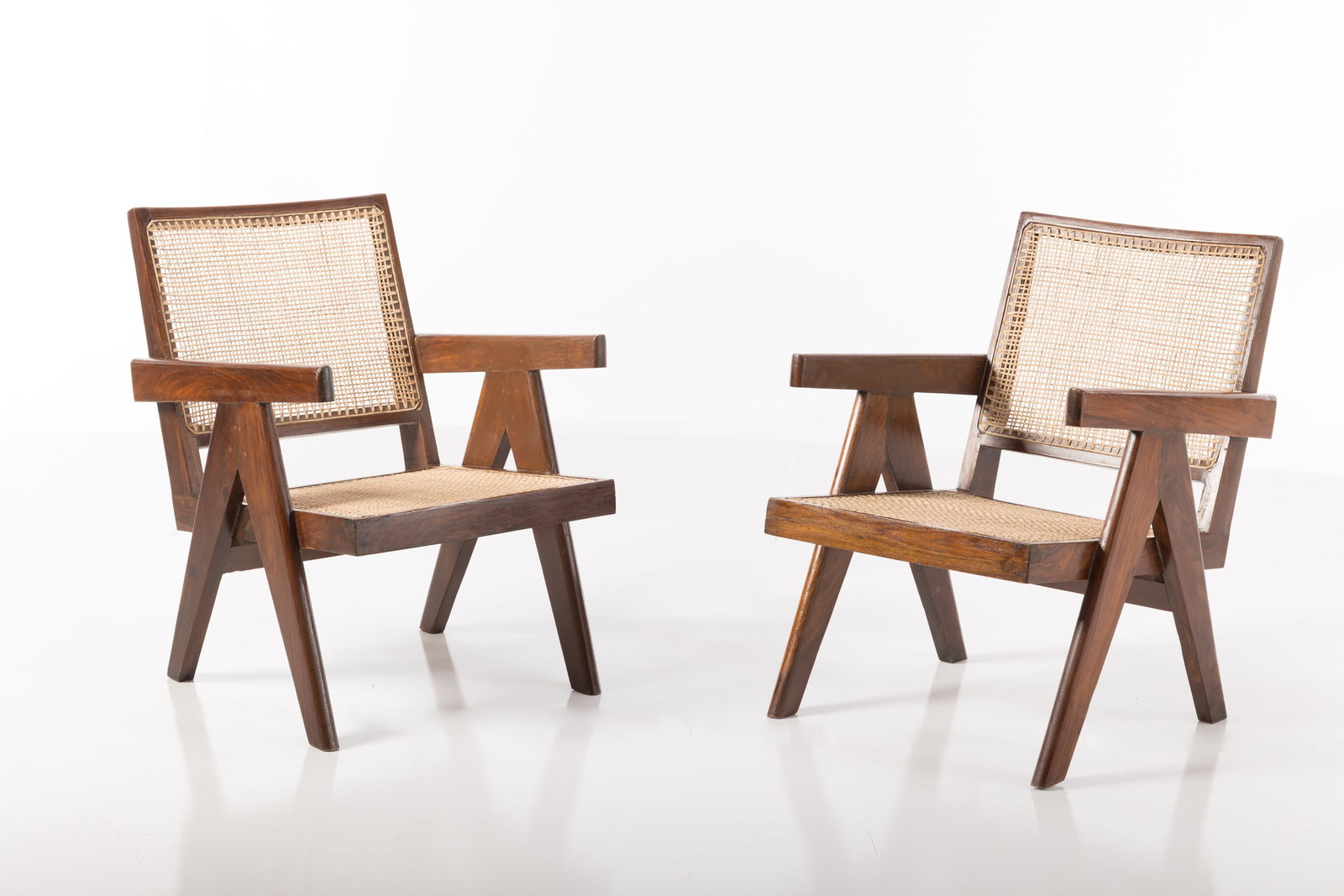 Pierre Jeanneret, Easy Chairs (2): PIERRE JEANNERET Pair of 'Easy' chairs, from Chandigarh, ca. 1957 Teak, cane, fabric. Produced in France / India for Punjab University, Chandigarh, India. Each with painted