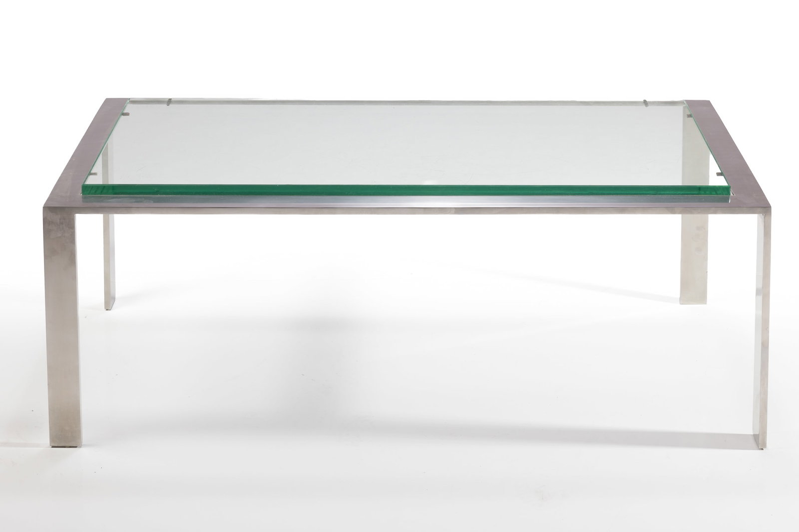 Jacques Adnet Style, Coffee Table: JACQUES ADNET STYLE Coffee table, 20th century Matte flat steel, glass. 16" H x 44" W x 22" D