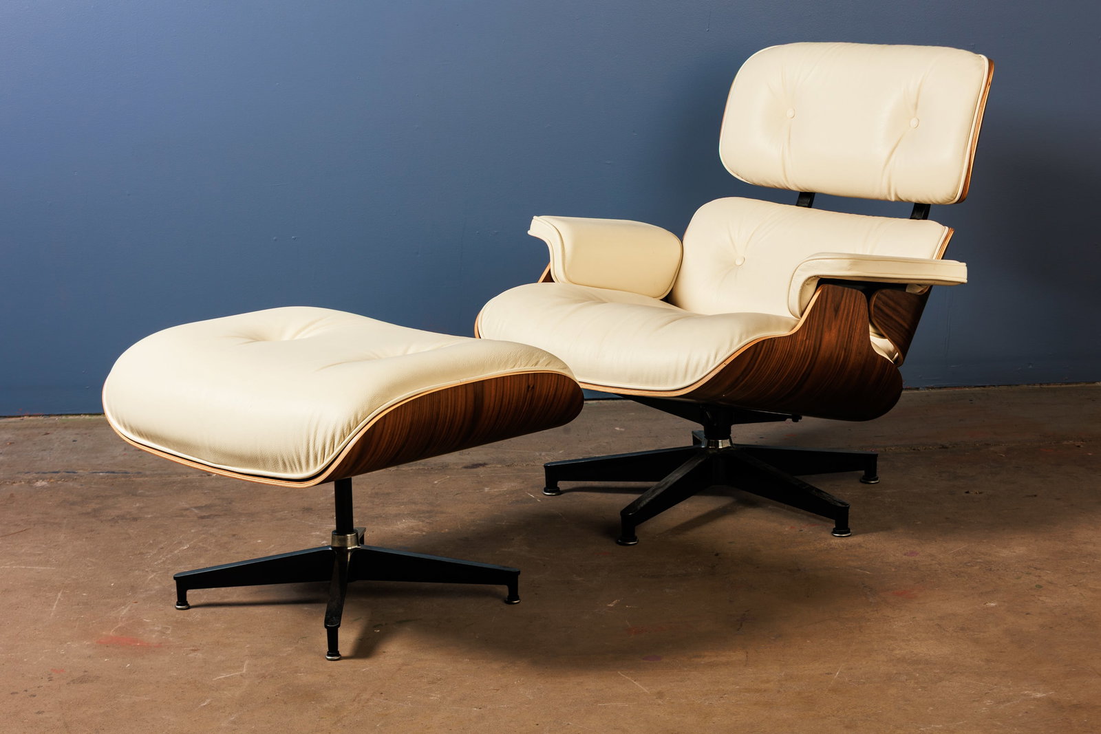 Charles + Ray Eames, Lounge Chair + Ottoman (2): CHARLES + RAY EAMES Lounge chair and ottoman, model nos. 670 and 671, 2022 Walnut-veneered plywood, leather, enameled and brushed aluminum. Manufactured by Herman Miller, USA. Underside of each with m