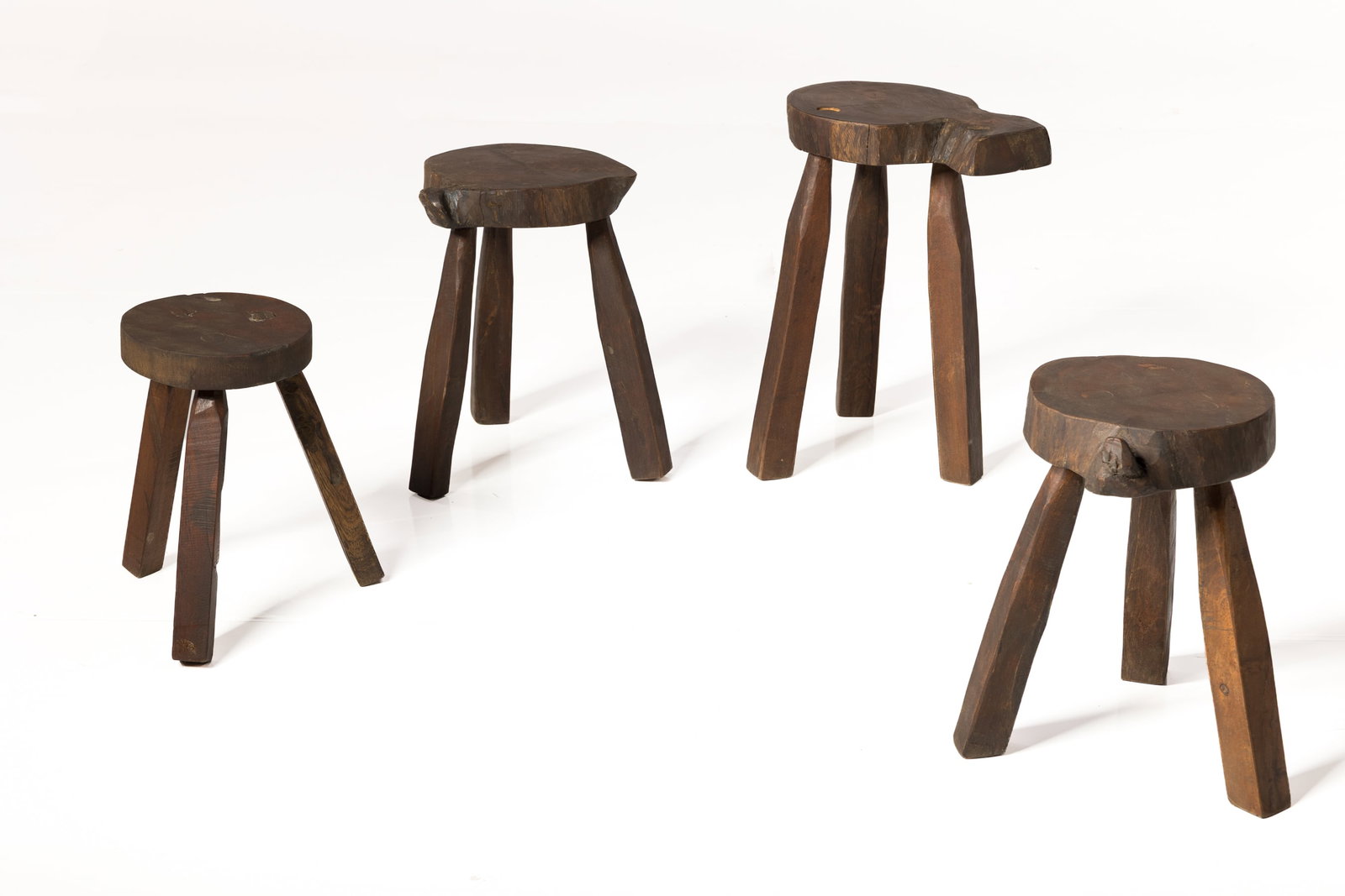 Rustic, Milking Stools (4): RUSTIC Set of four stools, late 20th century Stained wood. Largest: 18.75" H x 13" W x 11" D