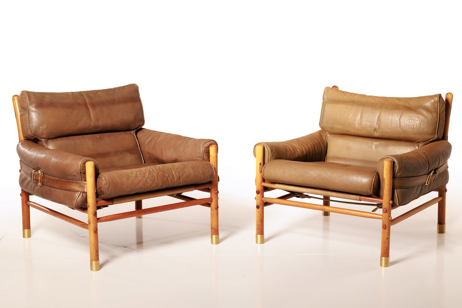 Arne Norell, 'Kontiki' Lounge Chairs (2): ARNE NORELL Pair of 'Kontiki' lounge chairs, ca. 1970 Leather, stained beech, brass. Produced by Norell, Sweden. Underside of seat cushion with producer's label. Each: 30" H x