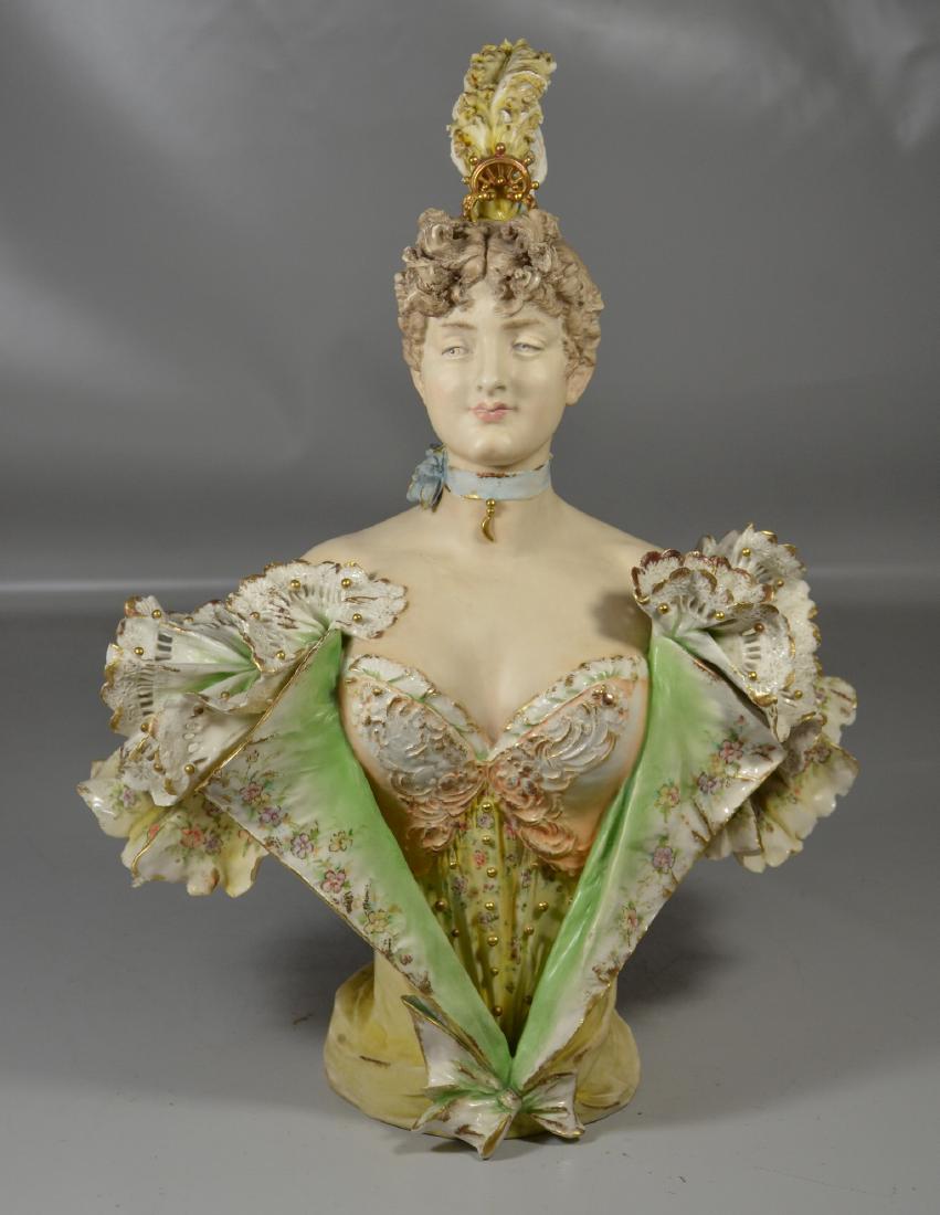 Continental Porcelain Bust of a Woman: Continental porcelain bust of a woman with feathers in her hair, large crack to base, feather headdress broken and reglued, repair to cloak on right side, 19" h