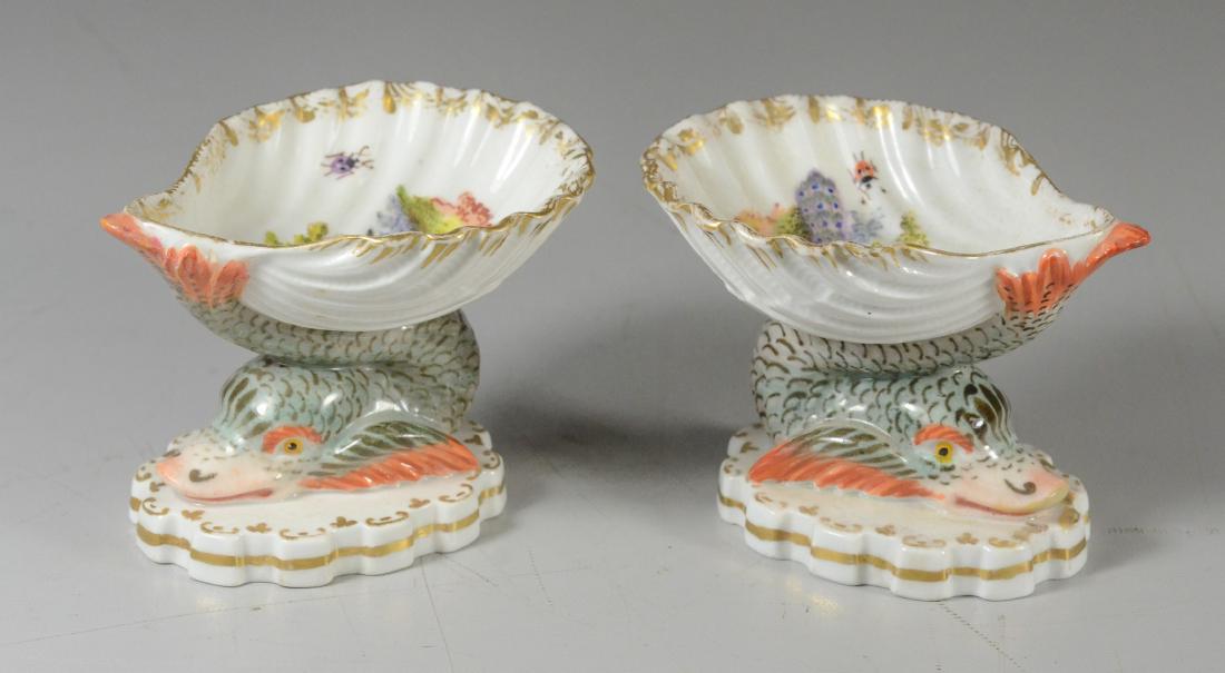 Pr Berlin porcelain 'Dolphin & Nautilus' salt cellars: Pair of Berlin porcelain 'Dolphin and Nautilus' salt cellars, circa 1900, each interior shell decorated with pea fowl and birds and butterflies, each with underglaze blue scepter mark, 2-1/2" H