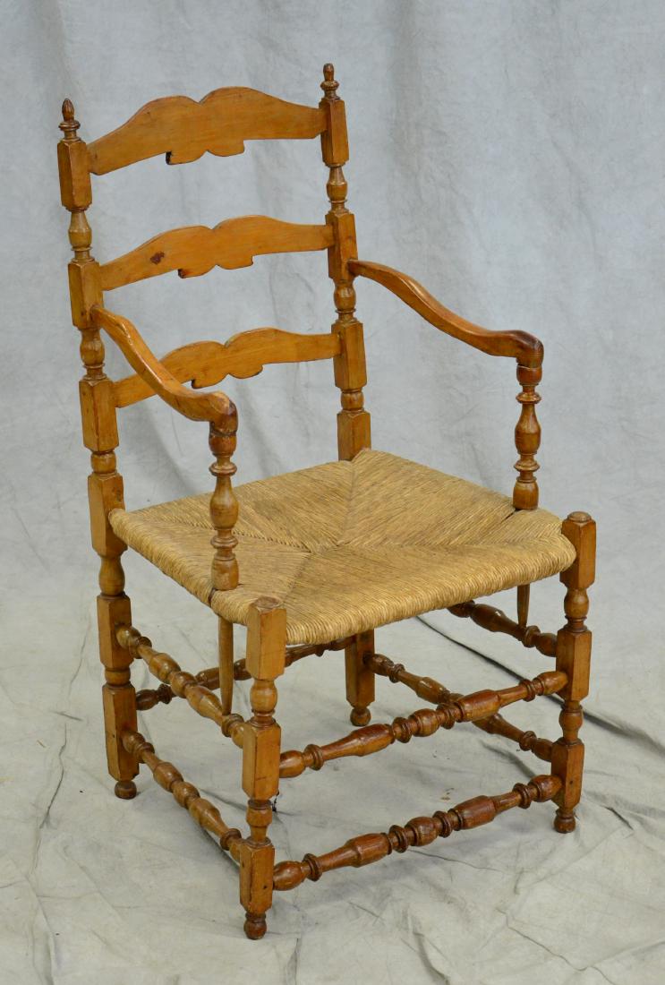Ladderback turned post and stretcher rush NE chair: Unusual ladderback turned post and stretcher rush seat double bearing armchair, New England or Canada, 40" h x 22" w x 21" d, good condition with restorations, badly refinished, legs do not appear to 