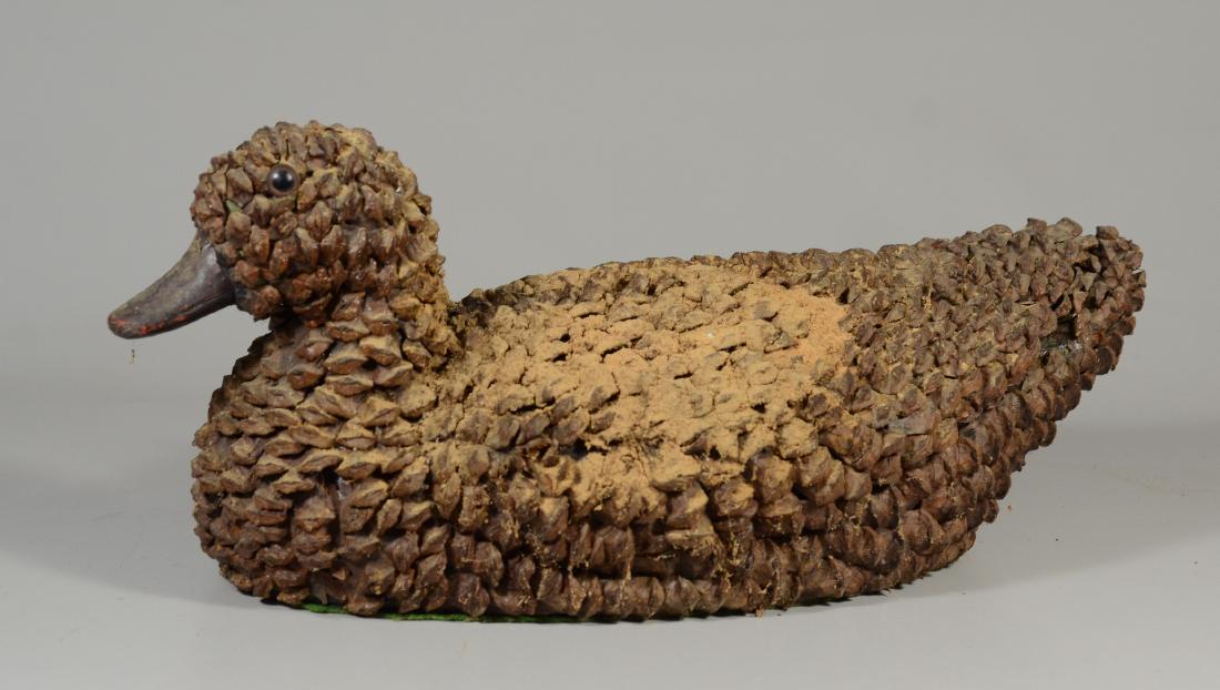 Primitive pine cone duck decoy w/glass eyes: Primitive pine cone duck decoy w/glass eyes, some losses to "feathers", 20" long