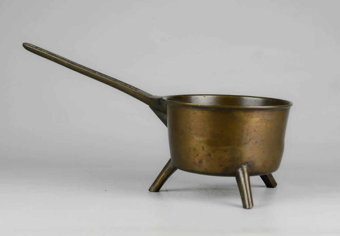 18th C Warner Bronze Posnet Pot: 18th C bronze posnet pot, embossed on handle "Warner 4P", stands on 3 legs, pot 7-1/4" dia x 4" deep, 16-1/4" x 7-1/4" x 8-1/2" h overall
