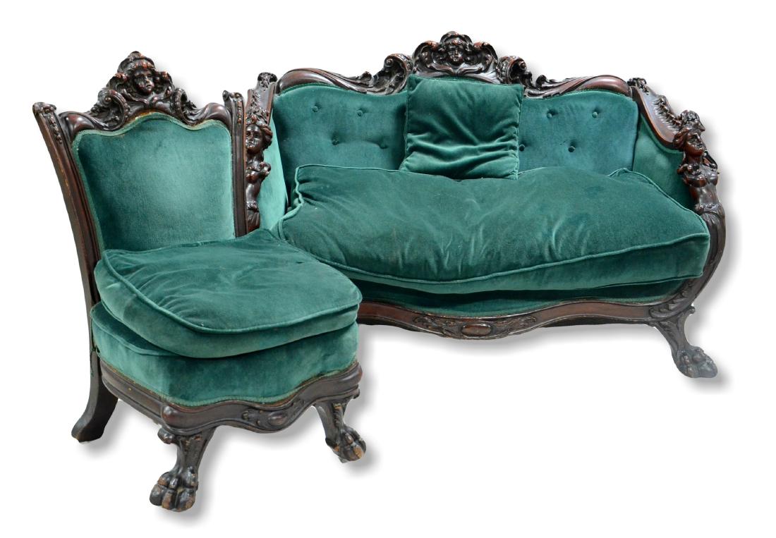Figural carved mahogany Victorian settee with chair: Figural carved mahogany Victorian settee with chair, settee with putti head crest, nude women on arms, paw feet, chair with similar crest, green velvet upholstery, settee 55" w, 37" h, toes have scuff