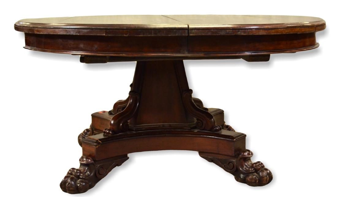 Mahogany Empire style dining table: Mahogany Federal style round pedestal dining table,base with inverted dolphins and claw feet, 57"diameter, (2) 12:" leaves